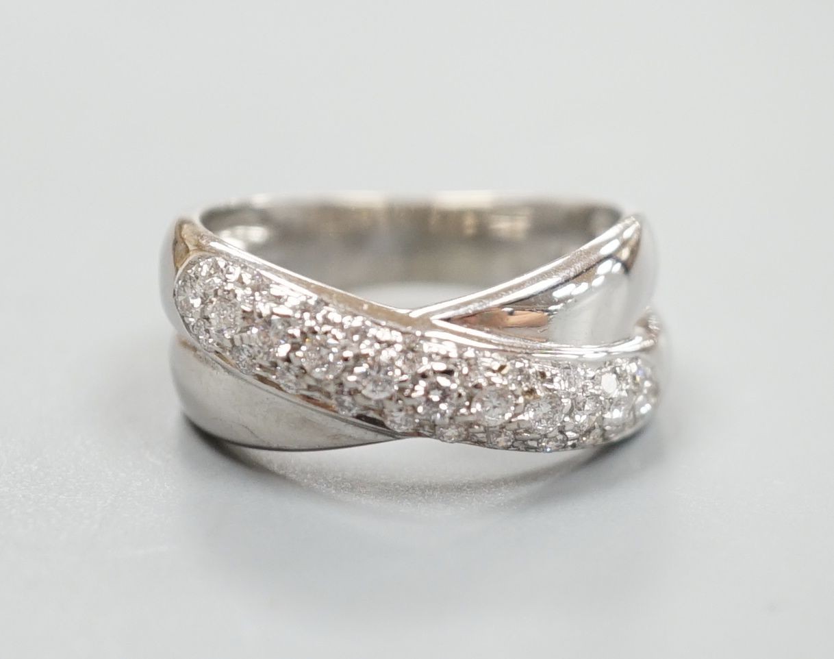 A modern 750 white metal and pave set diamond crossover ring, size L/M, gross weight 5.9 grams.